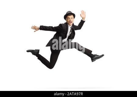 Junger Kerl in Anzug und Hut hüpfend hoch isoliert auf weißem Hintergrund Stockfoto