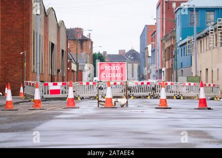 Straßenfahrt mit geschlossenem Schild mit den Verkehrskegeln und dem roten Absperrzaun Stockfoto