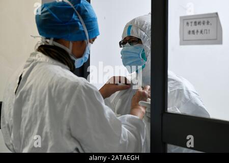 Fuzhou, Chinas Provinz Fujian. Januar 2020. Ein medizinischer Arbeiter hilft einem Arzt, den Schutzanzug anzubringen, bevor er eine Isolationsstation am Fuzhou Pulmonary Hospital von Fujian in Fuzhou, südsüdchinesische Provinz Fujian, 31. Januar 2020 betritt. Das Krankenhaus ist ein ausgewiesenes Krankenhaus zur Behandlung von Lungenentzündung, die durch das neuartige Coronavirus verursacht wird. Es verfügt über zwei Etagen mit Isolationsstationen sowie 8 Ärzte und 34 Krankenschwestern, die rund um die Uhr arbeiten. Credit: Wang Yi/Xinhua/Alamy Live News Stockfoto