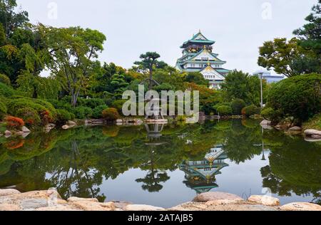 Die traditionellen japanischen Garten im Inneren bailey Burg von Osaka mit den fünf Geschichten Main Tower (tenshu) im Hintergrund. Chuo-ku. Osaka. Japan Stockfoto