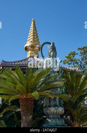 Der Blick auf die Statue von Kannon und Pagode mit geschwungenem Dach mit goldenem sorin auf der Spitze am Isshinji-Tempel. Tennoji. Osaka. Japan Stockfoto