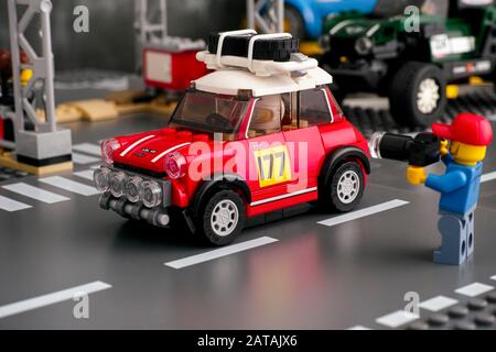 Tambov, Russische Föderation - 18. August 2019 Lego-Mann mit Kamera nimmt ein Bild von Mini Cooper S Rally Auto von LEGO Speed Champions auf der Straße BAS auf Stockfoto