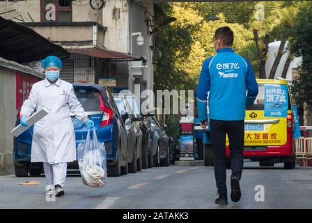 (200201) -- WUHAN, 1. Februar 2020 (Xinhua) -- EIN Mitnahme-Mitarbeiter geht am 31. Januar 2020 an einem Krankenhaus in Wuhan, der zentralchinesischen Provinz Hubei, vorbei. Mitten in einer schweren Epidemie verlor Wuhan in der zentralchinesischen Provinz Hubei die Hektik der Vergangenheit, mit wenigen Autos und Fußgängern auf den Straßen. Für die Menschen, die zu Hause bleiben, um die Infektion des neuartigen Coronavirus zu vermeiden, sind die Mitnahmeerlöser in der Stadt zur Brücke zwischen ihnen und der Außenwelt geworden.Yang Hu, ein leitender Mitarbeiter von "Eleme", Alibabas Flaggschiff der "Takeaway-ordering App", ist für die verantwortlich Stockfoto