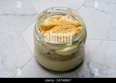 Hausgemachter Pudding Banana mit Baby-Keks-Pulver. Türkische Magnolia Dessert in Glass Bowl. Organisch Gesundes Dessert. Stockfoto