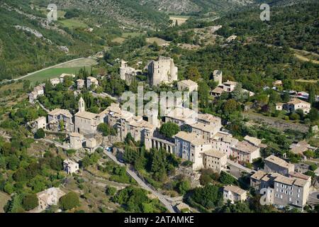 LUFTAUFNAHME. Provenzalisches Dorf auf einem Hügel erbaut, gekrönt von einer mittelalterlichen Burg in Ruinen. Montbrun-les-Bains, Drome, Frankreich. Stockfoto