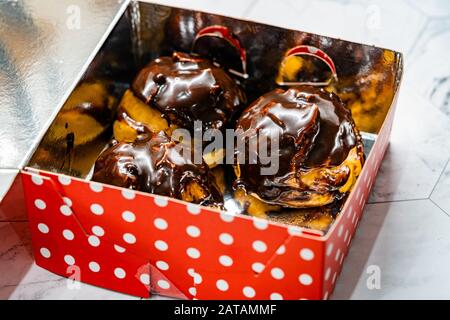 Nehmen Sie Das französische Dessert mit Cremefarben Schokolade Eclair in Kunststoff-Box-Paket weg. Makroansicht Schließen. Bereit zum Essen. Stockfoto