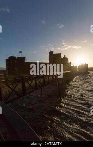 Blackness Castle, Blackness, Schottland. Silhouettenblick auf die westliche façade der Burg Der Schwärmerei, mit der Pier aus dem 19. Jahrhundert im Vordergrund. Stockfoto