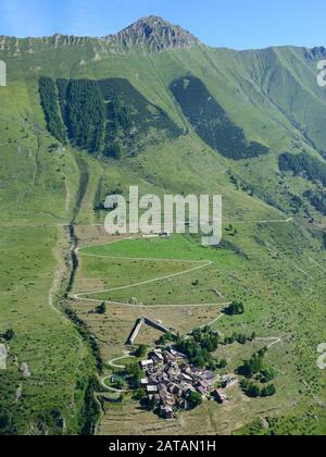 LUFTAUFNAHME. Kleines Alpendorf mit Schneebarre zum Lawinenschutz. Pequerel, Metropolregion Turin, Piemont, Italien. Stockfoto