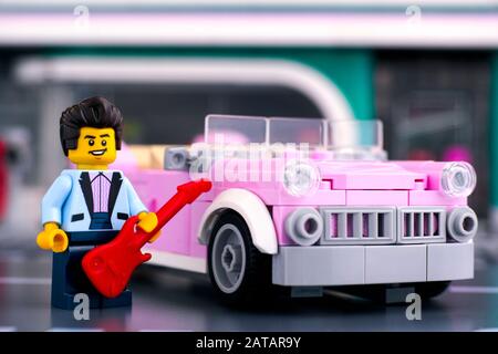 Tambov, Russische Föderation - 22. Januar 2020 Lego Rosa 1950er-Stil Cabrio und Rock n Roll Star Minifigure mit Gitarre in der Nähe. Studio gedreht. Stockfoto