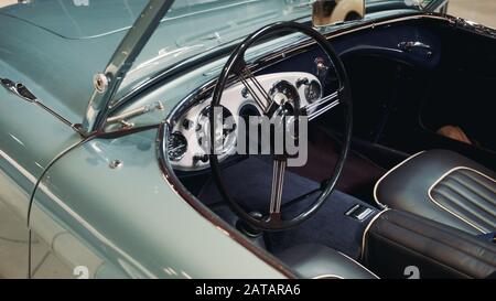 Innenraum des himmelblauen Oldtimers: Rad, Armaturenbrett und Leder sitzen Stockfoto