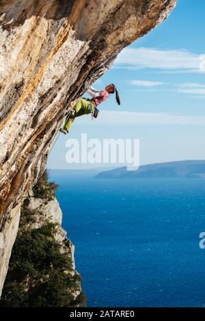 Junge Kletterin, die in Kroatien einen clif über der Adria erklimmen. Stockfoto