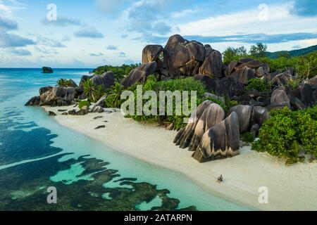 Touristen an einem schönen Strand mit weißem Sand auf einer tropischen Insel auf den Seychellen - Dem berühmten Strand von Anse d'Argent in La Digue Stockfoto