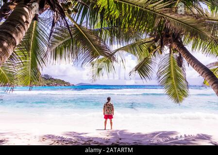 Touristen an einem schönen Strand mit weißem Sand auf einer tropischen Insel auf den Seychellen - Dem berühmten Strand von Anse d'Argent in La Digue Stockfoto