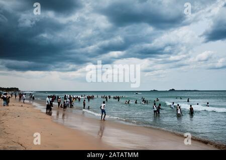 Familien aus Sri Lanka genießen freie Zeit an einem tropischen Strand in Trincomalee. Stockfoto