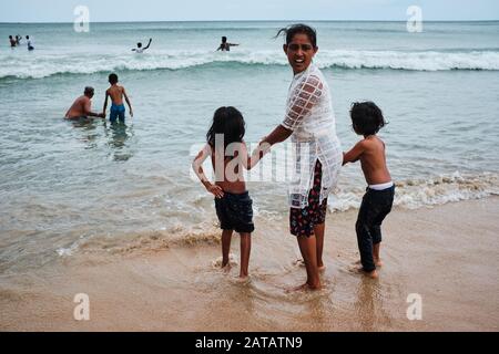 Familien aus Sri Lanka genießen freie Zeit an einem tropischen Strand in Trincomalee. Stockfoto