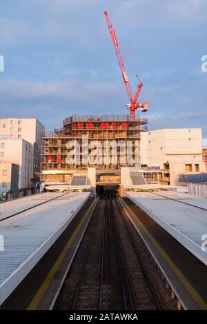 Baustelle mit lupendem Jib-Turmkran bei der Arbeit / an dem, was der Twickenham Gateway Hauptbahnhof sein wird, bestehend aus Wohnimmobilienunterkünften und Einzelhandelsgeschäften. London. GROSSBRITANNIEN. (112) Stockfoto