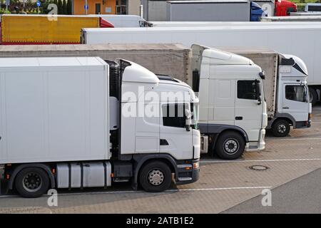 Rastplatz. Verschiedene Lkw-Typen auf dem Parkplatz neben der Autobahn. Stockfoto