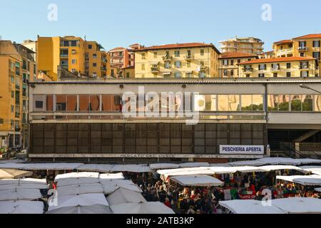 Blick auf den überfüllten Straßenmarkt vor dem Marktbereich Mercato Annonario im Stadtzentrum von Sanremo, Imperia, Ligurien, Italien Stockfoto