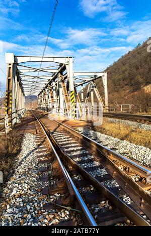 Eisenbahnbrücke aus Metall über den Fluss Svratka in der Nähe der Stadt Tisnov in Tschechien - EU. Transport auf Schienen. Eisenbahn-Verkehrsinfrastruktur. Stockfoto