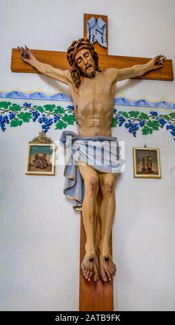 Badia (BZ), 10. februar 2019: Licht erleuchtet die Statue der Kreuzigung Jesu Christi Stockfoto