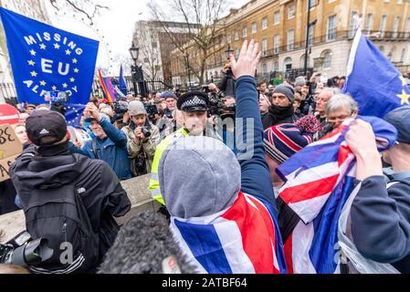 Wütende Brexiteers schängern Anti-Europa-Botschaften bei Pro-EU-remainern am Brexit-Tag, 31. Januar 2020, in London, Großbritannien. Polizist trennt Fraktionen Stockfoto