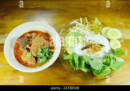 Reisnudeln und frisches Gemüse essen mit würzigem Schopfschwein und roter Baumwollbaumsoße mit Knochen Stockfoto