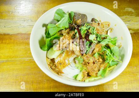 Reisnudeln und frisches Gemüse essen mit würzigem Schopfschwein und roter Baumwollbaumsoße mit Knochen Stockfoto