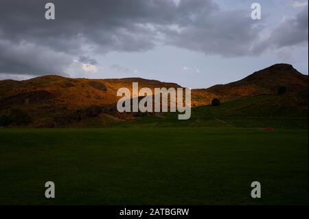 Sonnenschein bei Sonnenuntergang über dem Holyrood Park. Gorse Bush bietet eine erstaunliche gelbliche Farbe während der Frühlings- und Sommermonate. Edinburgh Stadtbild/Reise-Fotogalerie Stockfoto