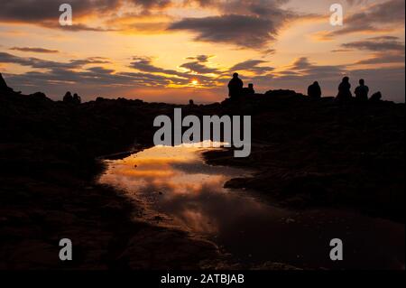 Menschen, die den Sonnenuntergang über Edinburgh auf Arthurs Sitzgipfel genießen. Stadtbild/Reisefotografie von Edinburgh von Pep Masip. Stockfoto