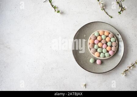 Süße japanische Mochi-Rice-Kuchen, bunte Moji-Kuchen mit Frühlingsblüte, Draufsicht, Kopierraum. Stockfoto