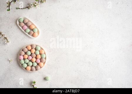 Japanische Mochi Rice Cakes, bunte süße Moji Cakes mit Frühlingsblüte, Draufsicht, Kopierraum. Stockfoto