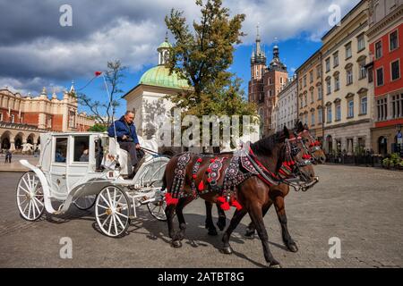 Krakow, Polen - 24. September 2018: Pferdekutsche mit Touristen auf Besichtigungstour am Hauptplatz in der Altstadt, historisches Stadtzentrum Stockfoto