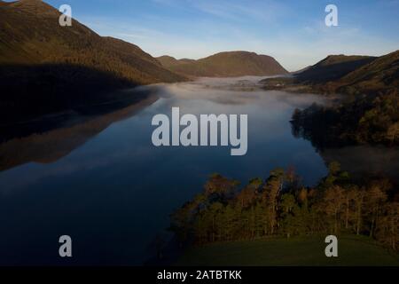 Morgennebel steigt um Buttermere, den See im englischen Lake District in Nordwestengland. Das angrenzende Dorf Buttermere hat seinen Namen Stockfoto