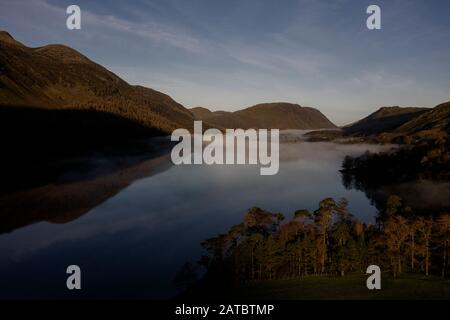 Morgennebel steigt um Buttermere, den See im englischen Lake District in Nordwestengland. Das angrenzende Dorf Buttermere hat seinen Namen Stockfoto