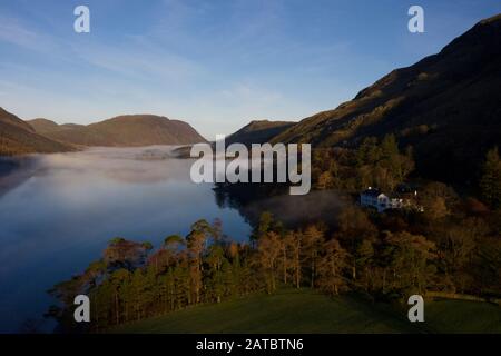 Morgennebel steigt um Buttermere, den See im englischen Lake District in Nordwestengland. Das angrenzende Dorf Buttermere hat seinen Namen Stockfoto