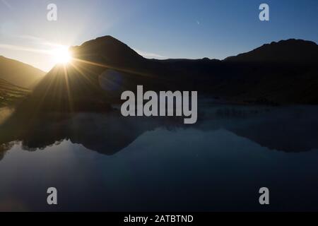 Morgennebel steigt um Buttermere, den See im englischen Lake District in Nordwestengland. Das angrenzende Dorf Buttermere hat seinen Namen Stockfoto