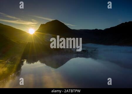 Morgennebel steigt um Buttermere, den See im englischen Lake District in Nordwestengland. Das angrenzende Dorf Buttermere hat seinen Namen Stockfoto