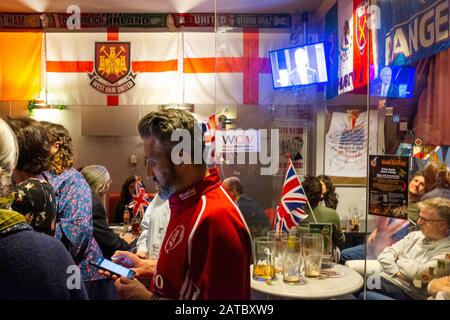 Ein Mann liest sein Handy, während sich die Europäer zum Gedenken an die Brexit Night, den letzten Tag der UKs in der EU, in einer britischen Kneipe am 31. Januar in Wien, Österreich versammeln Stockfoto
