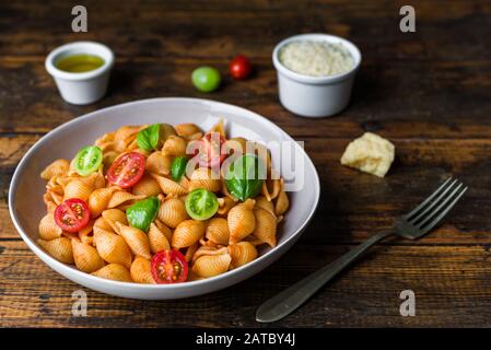 Conchiglie Abissine Torte Pasta mit Tomatensauce, Kirschtomaten und Basilikum Stockfoto