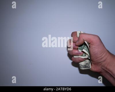 Die Hand hält und drückt die Dollar. Stockfoto