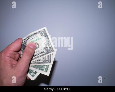 Die Hand hält und drückt die Dollar. Stockfoto