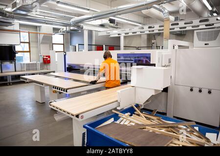 Ein Arbeiter arbeitet an einer Holzbearbeitungsmaschine in einer Fabrik. Holz- und Holzwerkstoffindustrie. Stockfoto