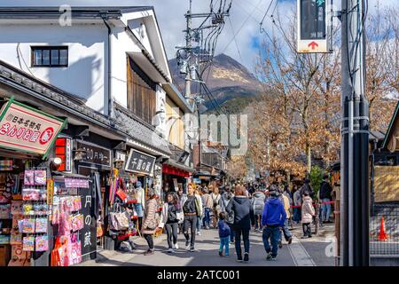 Stadtbild von Yufuin im Winter sonniger Tag mit klarem blauen Himmel. Viele Geschäfte auf der Straße, Touristen kommen in den Neujahrstagen zu Besichtigungen Stockfoto