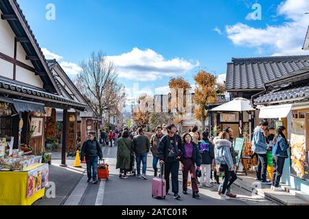 Stadtbild von Yufuin im Winter sonniger Tag mit klarem blauen Himmel. Viele Geschäfte auf der Straße, Touristen kommen in den Neujahrstagen zu Besichtigungen Stockfoto