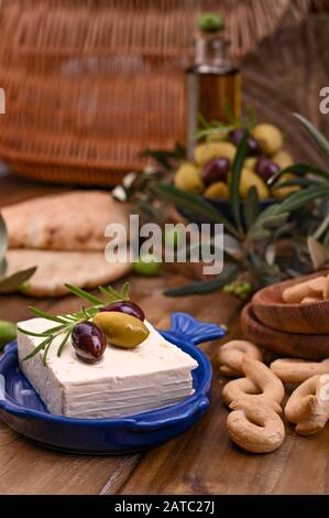 Griechische Fetakäse und Oliven verschiedener Sorten. Traditionelles Brot und Krokodile auf Holzgrund. Kopierbereich Stockfoto