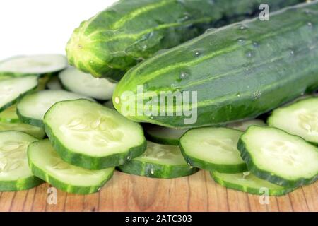 Ganze und geschnittene Gurke auf Holztisch Stockfoto