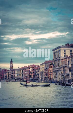 Die Gondel mit Touristen fährt am Abend in Venedig, Italien, entlang des Canal Grande. Die Gondel ist der attraktivste Touristentransport Venedigs. Stockfoto