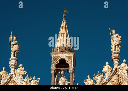 Statuen auf der Spitze des Markusdoms, Venedig, Italien. Diese alte Kathedrale ist das wichtigste Wahrzeichen Venedigs. Verzierte Fassade der berühmten markuskur Stockfoto