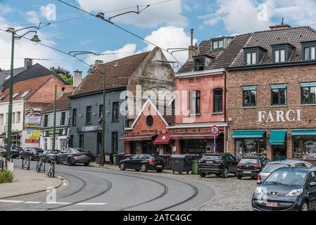 Uccle, Brüssel / Belgien - 06 13 2019: Traditionelle Handelsstraße mit Restaurants, Geschäften, Bistros und einer Tramway Bahnwaytrack am Saint Job Square Stockfoto