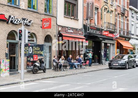 Uccle, Brüssel / Belgien - 06 14 2019: Menschen, die auf sonnigen Terrassen am Stadtplatz Saint Job essen und trinken